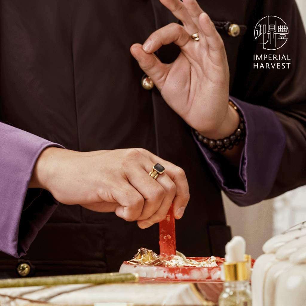 Master David carries out consecration rites at Imperial Harvest, using mudra gestures in grinding ceremonial red vermilion