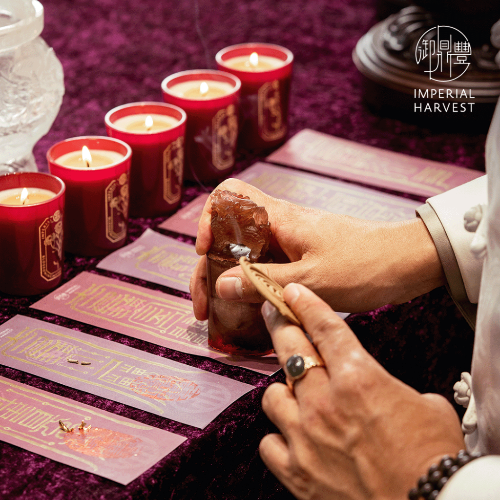 Master David conducting the consecration ceremony, stamping the talismans with red vermillion.